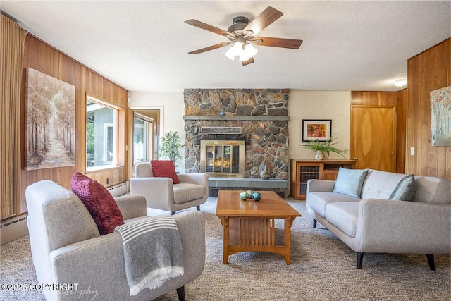 15021 Old Seward Hwy, Anchorage, AK 99516 - living area with wooden walls, a ceiling fan, carpet flooring, baseboard heating, and a stone fireplace