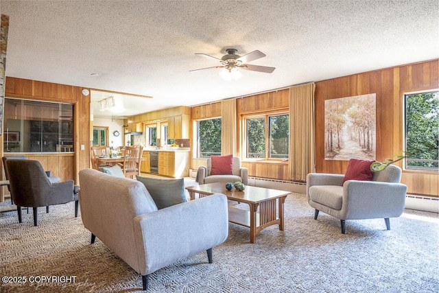 15021 Old Seward Hwy, Anchorage, AK 99516 - living area featuring wooden walls, carpet floors, a ceiling fan, a textured ceiling, and a baseboard heating unit