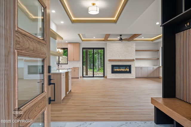 1770 S Corwin Ln, Wasilla, AK 99654 - kitchen with a ceiling fan, a raised ceiling, a stone fireplace, light countertops, and open floor plan