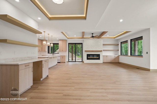 1770 S Corwin Ln, Wasilla, AK 99654 - kitchen featuring open shelves, a raised ceiling, a ceiling fan, a large fireplace, and recessed lighting
