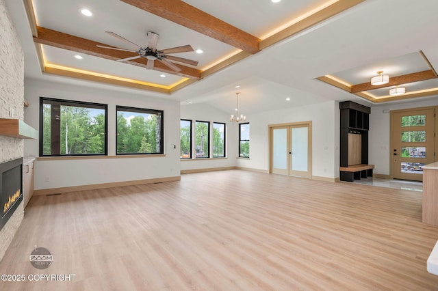 1770 S Corwin Ln, Wasilla, AK 99654 - unfurnished living room with a fireplace, light wood-style flooring, a tray ceiling, a chandelier, and recessed lighting