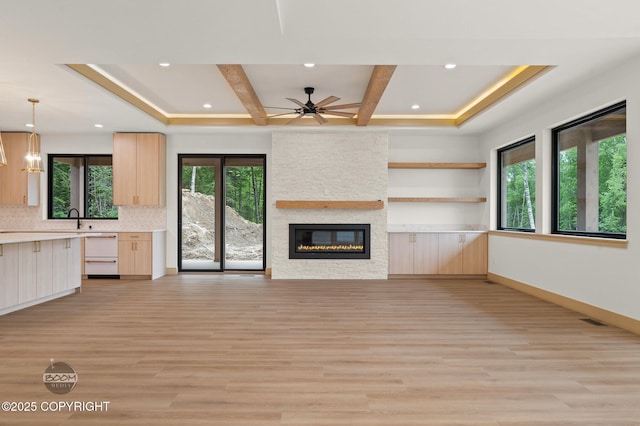1770 S Corwin Ln, Wasilla, AK 99654 - unfurnished living room featuring light wood-type flooring, ceiling fan, a stone fireplace, recessed lighting, and beam ceiling