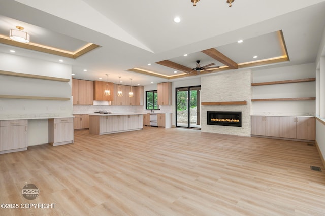 1770 S Corwin Ln, Wasilla, AK 99654 - unfurnished living room with a ceiling fan, a fireplace, light wood-style floors, a raised ceiling, and recessed lighting