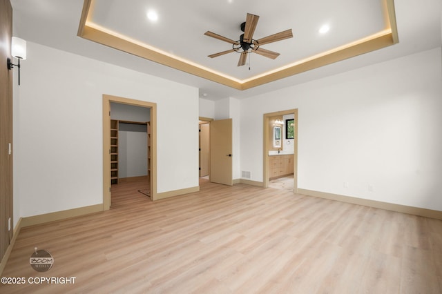 1770 S Corwin Ln, Wasilla, AK 99654 - unfurnished bedroom featuring a raised ceiling, a spacious closet, light wood-style flooring, recessed lighting, and connected bathroom