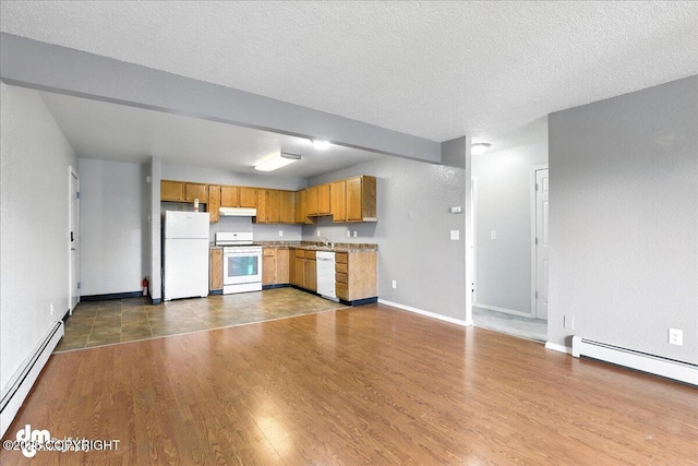 8203 Duben Ave, Anchorage, AK 99504 - kitchen with white appliances, a baseboard radiator, under cabinet range hood, a textured ceiling, and dark wood finished floors