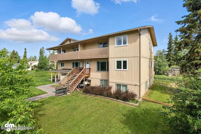 8203 Duben Ave, Anchorage, AK 99504 - back of property featuring a balcony, stairway, and a yard