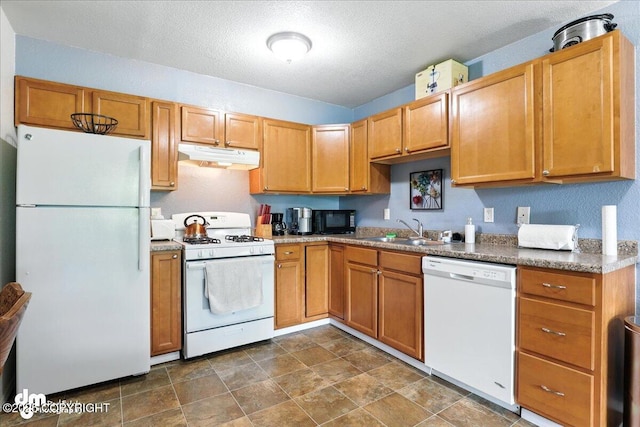 8203 Duben Ave, Anchorage, AK 99504 - kitchen featuring white appliances, under cabinet range hood, a textured ceiling, stone finish floors, and brown cabinets
