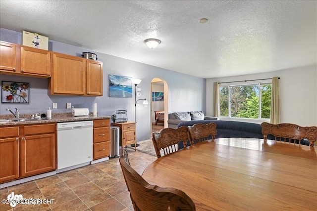 8203 Duben Ave, Anchorage, AK 99504 - kitchen with dishwasher, arched walkways, a textured ceiling, brown cabinetry, and open floor plan