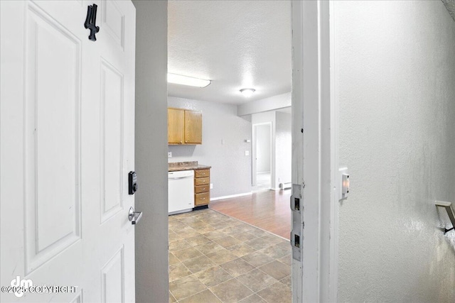 8203 Duben Ave, Anchorage, AK 99504 - kitchen featuring white dishwasher, a textured ceiling, stone finish floors, and light countertops