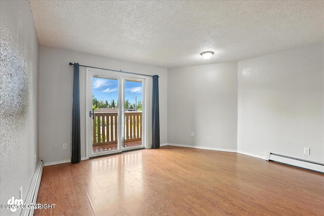 8203 Duben Ave, Anchorage, AK 99504 - spare room featuring wood finished floors, a textured ceiling, and baseboard heating