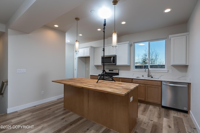 3680 Little Bear Pl Unit 8, Anchorage, AK 99504 - kitchen with stainless steel appliances, wooden counters, light wood-style flooring, recessed lighting, and a center island