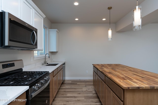 3680 Little Bear Pl Unit 8, Anchorage, AK 99504 - kitchen with stainless steel appliances, butcher block countertops, light wood-type flooring, recessed lighting, and white cabinetry