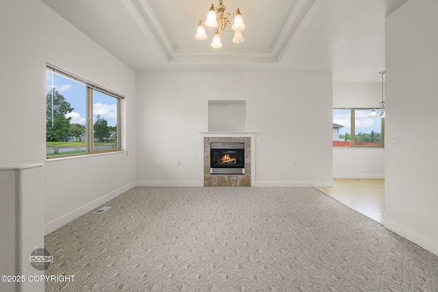 230 W Fallen Leaf Cir, Wasilla, AK 99654 - unfurnished living room featuring a chandelier, a tray ceiling, carpet floors, and a tile fireplace