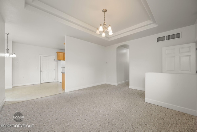 230 W Fallen Leaf Cir, Wasilla, AK 99654 - unfurnished room with a chandelier, arched walkways, a raised ceiling, and light carpet