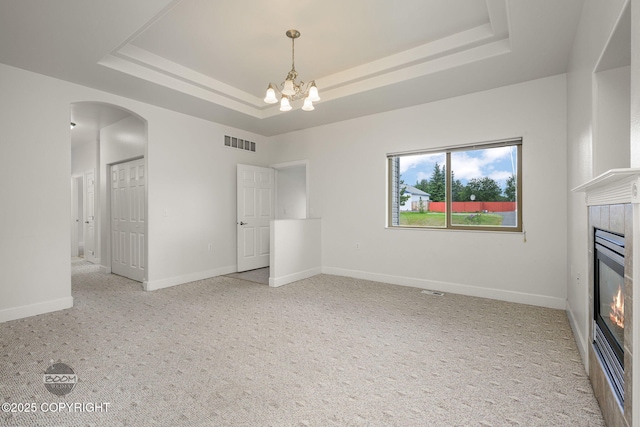 230 W Fallen Leaf Cir, Wasilla, AK 99654 - unfurnished living room featuring a raised ceiling, light carpet, and arched walkways