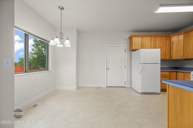 230 W Fallen Leaf Cir, Wasilla, AK 99654 - kitchen with freestanding refrigerator, a chandelier, light floors, and pendant lighting