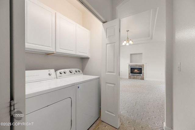 230 W Fallen Leaf Cir, Wasilla, AK 99654 - laundry area featuring cabinet space, light carpet, washing machine and clothes dryer, a chandelier, and a tiled fireplace