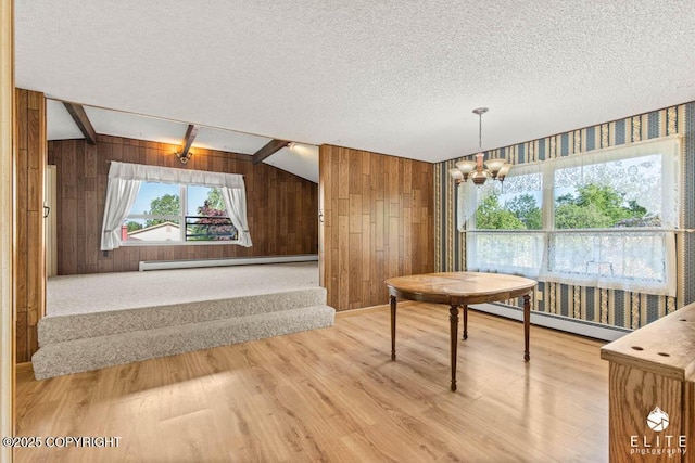13440 Diggins Dr, Anchorage, AK 99515 - dining room featuring a baseboard radiator, wooden walls, light wood finished floors, a chandelier, and a textured ceiling