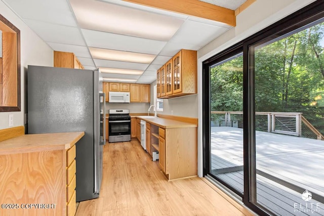 13440 Diggins Dr, Anchorage, AK 99515 - kitchen with stainless steel appliances, light wood-style flooring, light countertops, glass insert cabinets, and a paneled ceiling