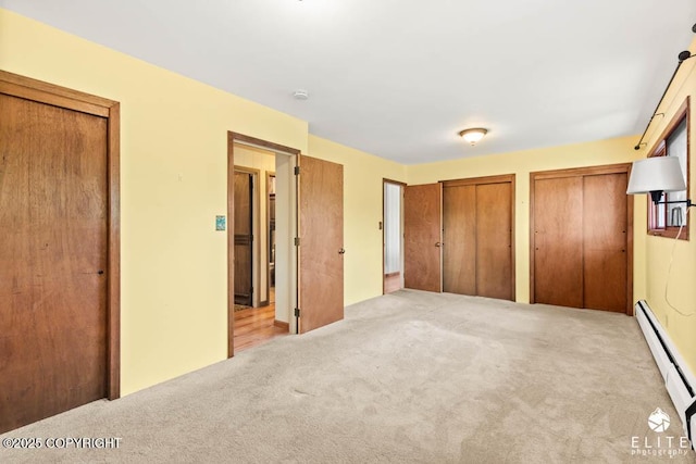 13440 Diggins Dr, Anchorage, AK 99515 - unfurnished bedroom with two closets, carpet floors, and a baseboard heating unit