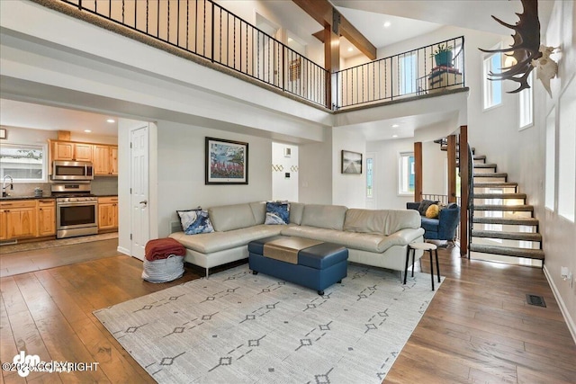 1535 M St, Anchorage, AK 99501 - living area with light wood-style flooring, stairs, and a high ceiling