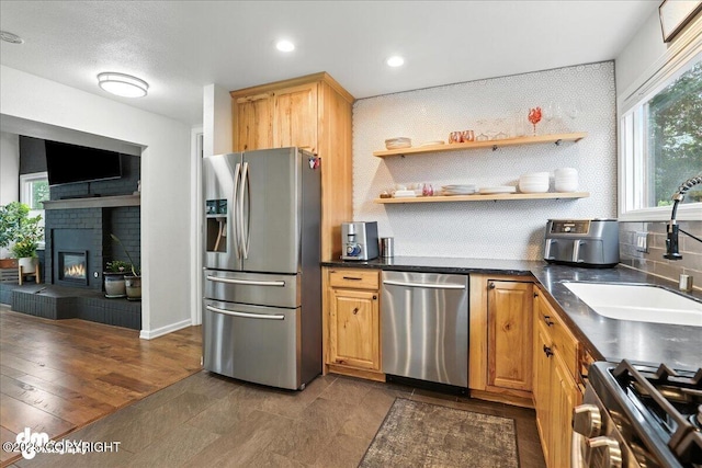 1535 M St, Anchorage, AK 99501 - kitchen featuring appliances with stainless steel finishes, dark countertops, decorative backsplash, a brick fireplace, and recessed lighting
