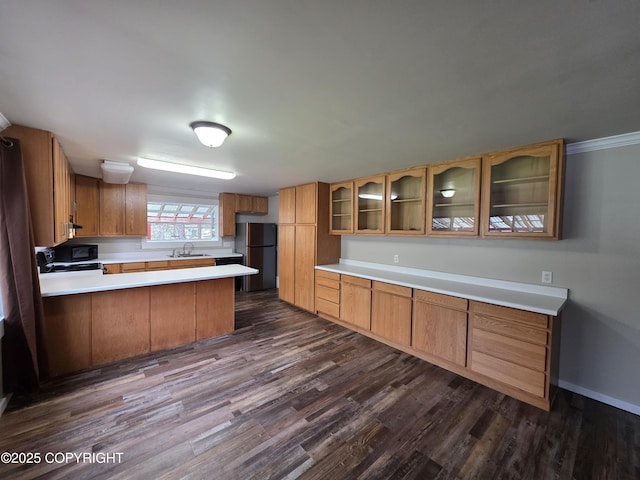 297 Mitkof Hwy, Petersburg, AK 99833 - kitchen with freestanding refrigerator, dark wood-style flooring, a peninsula, glass insert cabinets, and light countertops