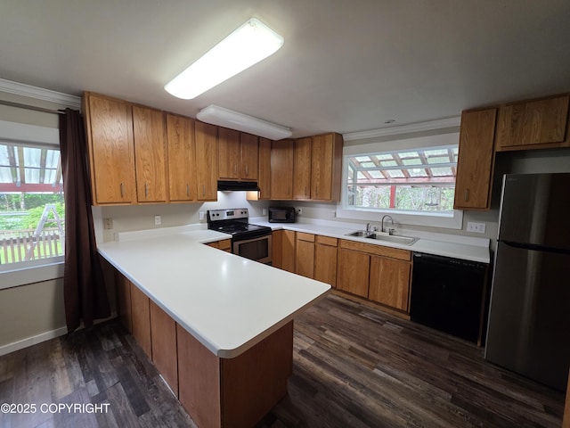 297 Mitkof Hwy, Petersburg, AK 99833 - kitchen with black appliances, under cabinet range hood, dark wood finished floors, a peninsula, and light countertops