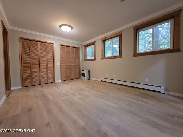 297 Mitkof Hwy, Petersburg, AK 99833 - unfurnished bedroom featuring baseboard heating, multiple closets, ornamental molding, and light wood-style floors