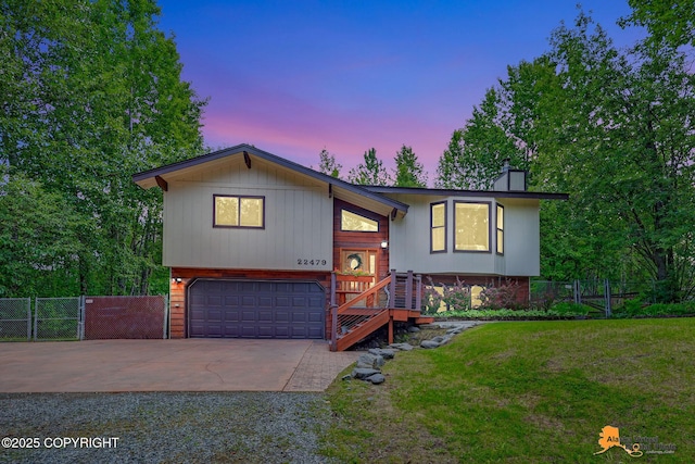22479 Centurion Dr, Chugiak, AK 99567 - bi-level home featuring concrete driveway, a chimney, a garage, and a gate