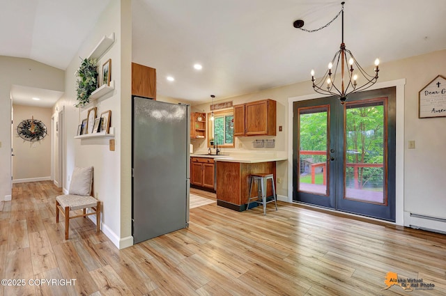 22479 Centurion Dr, Chugiak, AK 99567 - kitchen with brown cabinetry, freestanding refrigerator, light countertops, light wood-style floors, and open shelves