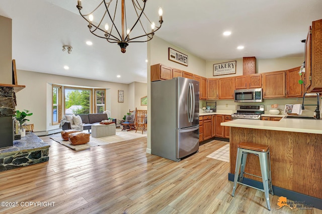 22479 Centurion Dr, Chugiak, AK 99567 - kitchen with appliances with stainless steel finishes, open floor plan, light countertops, a peninsula, and light wood-style floors