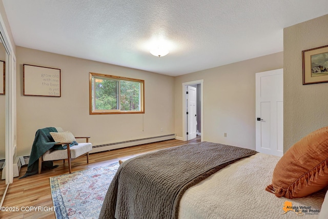 22479 Centurion Dr, Chugiak, AK 99567 - bedroom with baseboard heating, light wood finished floors, and a textured ceiling