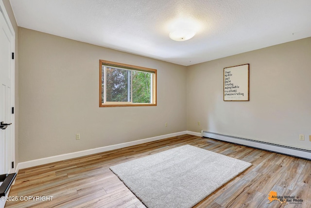22479 Centurion Dr, Chugiak, AK 99567 - unfurnished room with a baseboard radiator, wood finished floors, and a textured ceiling
