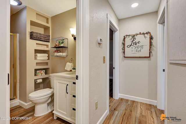22479 Centurion Dr, Chugiak, AK 99567 - bathroom featuring wood finished floors, vanity, a shower stall, and built in shelves