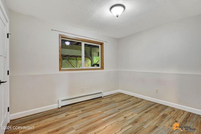 22479 Centurion Dr, Chugiak, AK 99567 - unfurnished room featuring a baseboard heating unit, wood finished floors, and a textured ceiling