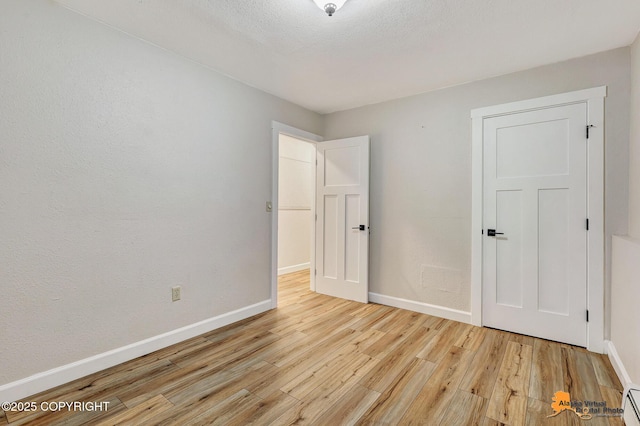 22479 Centurion Dr, Chugiak, AK 99567 - unfurnished bedroom featuring light wood finished floors and a baseboard radiator