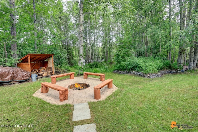 22479 Centurion Dr, Chugiak, AK 99567 - view of grassy yard featuring an outdoor fire pit and a view of trees