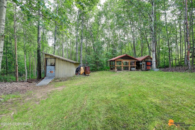 22479 Centurion Dr, Chugiak, AK 99567 - view of grassy yard featuring an outbuilding and a forest view
