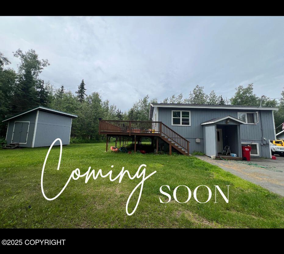 1060 E Mcadoo Way, Wasilla, AK 99654 - back of property featuring a deck, a lawn, stairway, and an outbuilding