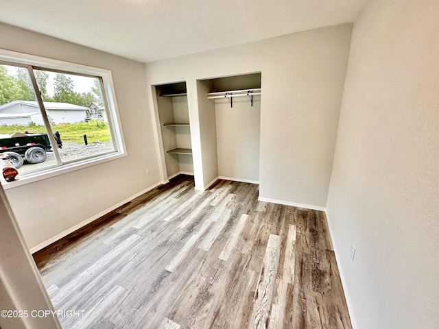 35870 Glory St, Soldotna, AK 99669 - unfurnished bedroom featuring two closets and wood finished floors