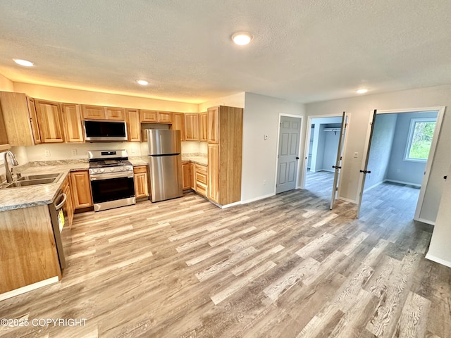 35870 Glory St, Soldotna, AK 99669 - kitchen with stainless steel appliances, a textured ceiling, light wood-style flooring, recessed lighting, and light stone counters