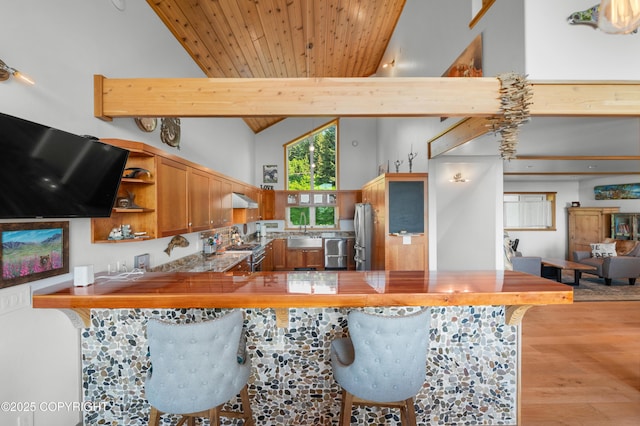 2500 W Highland Dr, Homer, AK 99603 - kitchen with open shelves, high vaulted ceiling, appliances with stainless steel finishes, light wood-style floors, and a peninsula