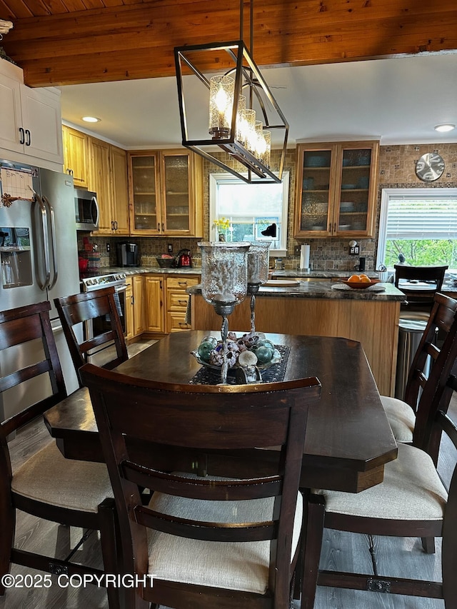 231 Main St, Seldovia, AK 99663 - kitchen with stainless steel appliances, backsplash, dark countertops, glass insert cabinets, and a chandelier