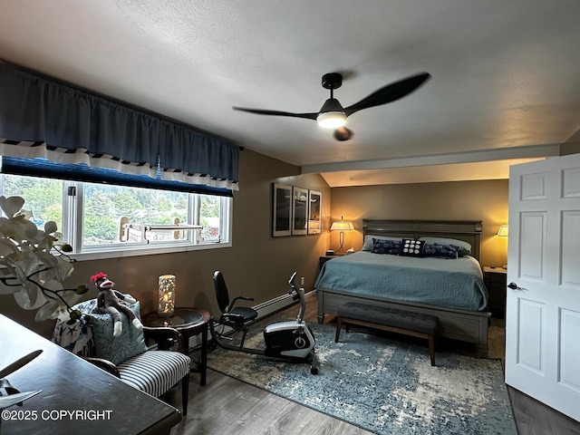 231 Main St, Seldovia, AK 99663 - bedroom with wood finished floors, ceiling fan, and a baseboard heating unit