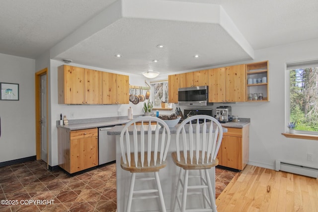 47000 Lexington Ct, Kenai, AK 99611 - kitchen featuring appliances with stainless steel finishes, baseboard heating, a kitchen island, open shelves, and recessed lighting