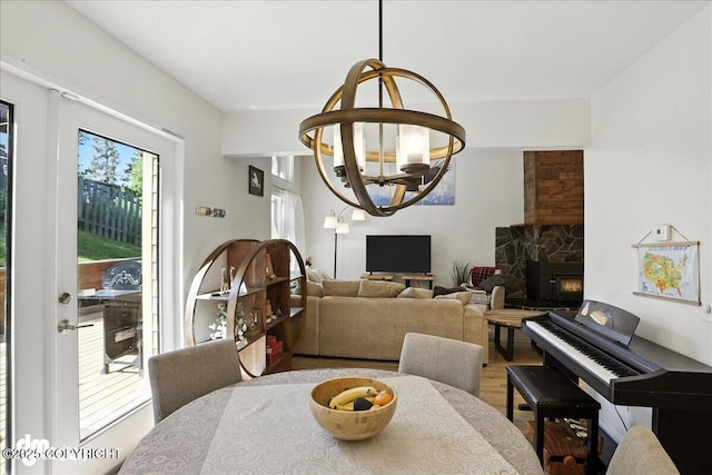 6622 Lakeway Dr, Anchorage, AK 99502 - dining area with a chandelier, wood finished floors, and a stone fireplace