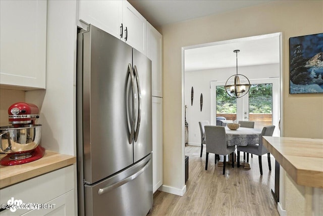 6622 Lakeway Dr, Anchorage, AK 99502 - kitchen featuring freestanding refrigerator, butcher block countertops, a chandelier, and light wood-style floors