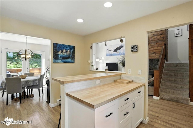 6622 Lakeway Dr, Anchorage, AK 99502 - kitchen featuring butcher block counters, white cabinetry, light wood-style floors, a chandelier, and recessed lighting