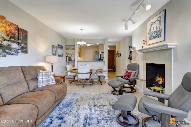 1200 I St Unit 314, Anchorage, AK 99501 - living room featuring a chandelier, light tile patterned floors, a fireplace, and rail lighting